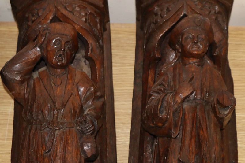 A pair of Italian carved oak figural wall shelves, length 42cm